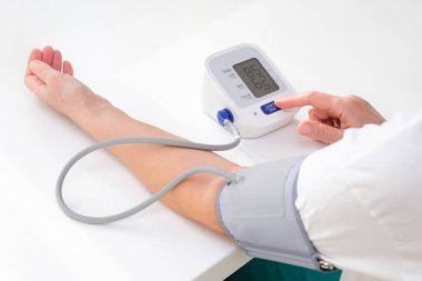 Man measures blood pressure, white background. arterial hypotension. hand and tonometer close up.
