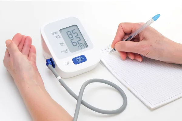 Person Measures Blood Pressure Writes Readings Notebook White Background Hand — Fotografia de Stock