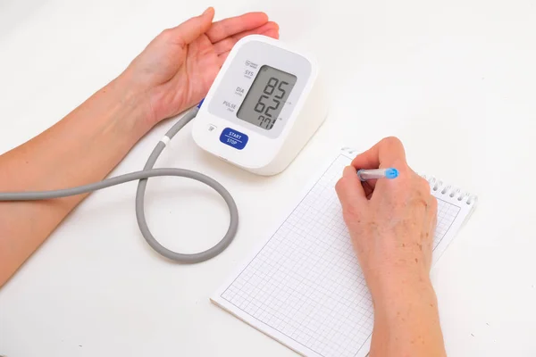 Person Measures Blood Pressure Writes Readings Notebook White Background Hand — Fotografia de Stock