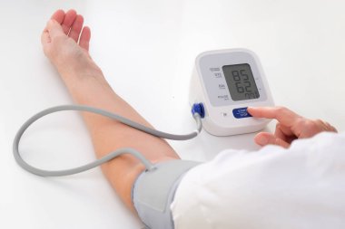 Man measures blood pressure, white background. arterial hypotension. hand and tonometer close up.