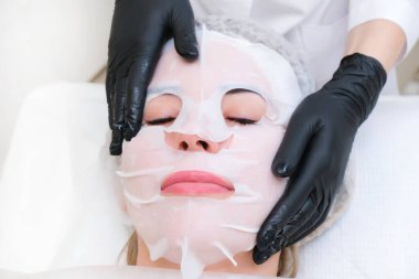 Yüz için kozmetik maske. Genç kadın yüz bakımı.