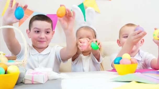 Tavşan Kulaklı Neşeli Çocuklar Paskalya Için Boyalı Yumurtalarla Oynuyorlar Çocuklar — Stok video