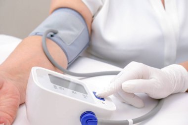 Doktor yetişkin birinin kan basıncını ölçer. Sağlık kavramı