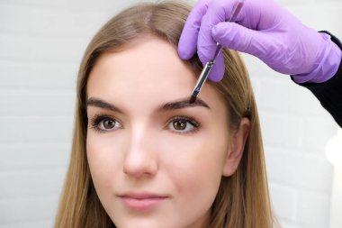 Kaşlarını fırçayla şekillendiren genç kadın, yaklaş.