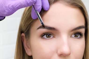 Kaşlarını fırçayla şekillendiren genç kadın, yaklaş.