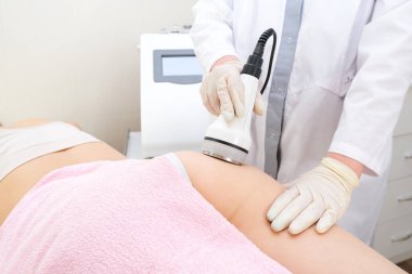 Süpürge masaj aleti. Kalça ve bacaklarda vakum masajı. Selülit önleyici vücut düzeltme tedavisi. Zayıflama aleti. Genç kadın ve doktor tıp fakültesinde..