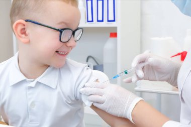 Küçük çocuk klinikte aşı oluyor, yakın çekim. Virüs önleme