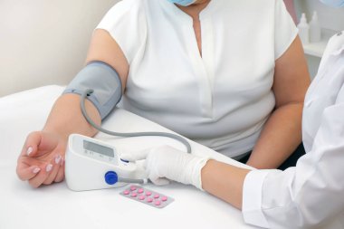 Doktor hastaya baskı için hap verir. Doktor yetişkin birinin kan basıncını ölçer. Sağlık kavramı.