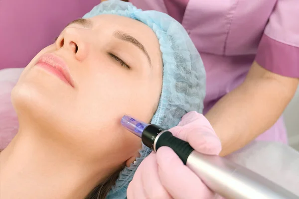 Needle mesotherapy. Cosmetologist performs needle mesotherapy on a womans face. Beautiful woman receiving microneedling rejuvenation treatment. Needle lifting