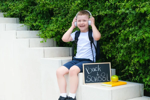 Szczęśliwy Uczeń Słuchawkach Trzymający Napis Powrót Szkoły Ulicy Drodze Szkoły — Zdjęcie stockowe