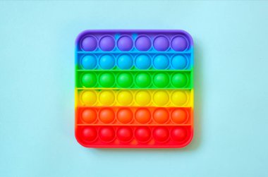 Gökkuşağı oyuncak hareketini boş fotokopi alanının arka planında yap. mavi arkaplan