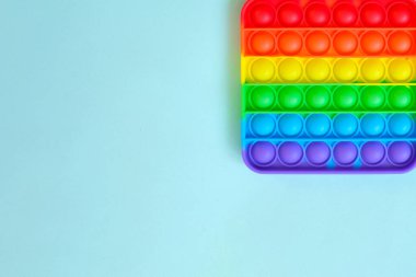 Gökkuşağı oyuncak hareketini boş fotokopi alanının arka planında yap. mavi arkaplan