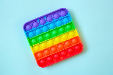 Gökkuşağı oyuncak hareketini boş fotokopi alanının arka planında yap. mavi arkaplan