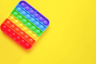 Gökkuşağı oyuncak hareketini boş fotokopi alanının arka planında yap. sarı arkaplan