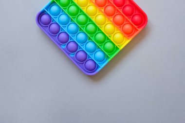 Gökkuşağı oyuncak hareketini boş fotokopi alanının arka planında yap. Gri arkaplan