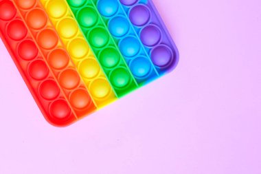 Gökkuşağı oyuncak hareketini boş fotokopi alanının arka planında yap. pembe arkaplan