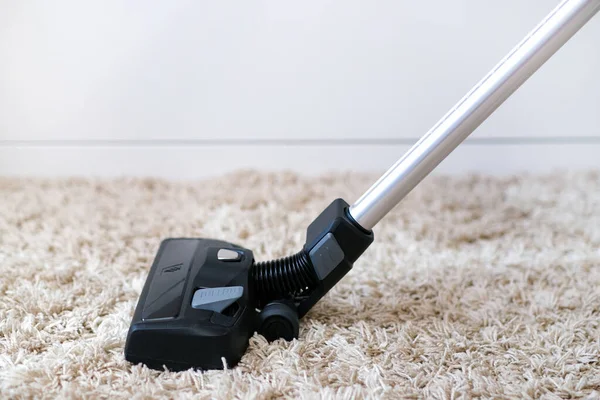 Kablosuz elektrik süpürgesi odadaki halıyı temizlemek için kullanılır. Yeni bir elektrikli süpürgeyle ev işi. Ev temizliği, bakım ve teknoloji konsepti.
