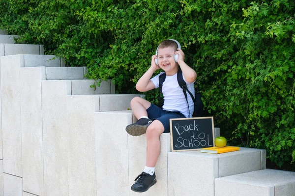 Menino Feliz Fones Ouvido Segurando Sinal Voltar Para Escola Rua — Fotografia de Stock