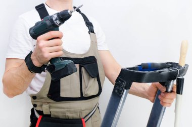 İşçinin elinde bir tornavida var. Özel tulumlu bir teknisyen.