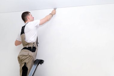 İşçi tavanı geriyor. İnşaat ve yenileme konsepti