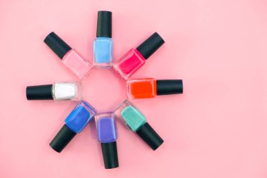 Pembe arka planda çok renkli tırnak cilası. Manikür kavramı