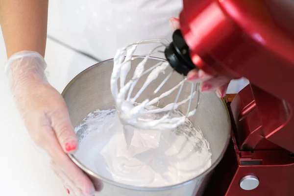 Beaten egg whites until frothy. Whipped egg whites for a meringue. Red stationary mixer, food processor
