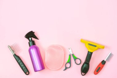 Pembe arka planda hayvan bakımı ve bakım aletleri. Hayvan bakımı ve hijyen konsepti. Boşluğu kopyala, metin için yer belirle. maket yap