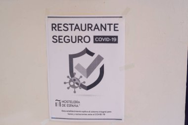6 Kasım 2020 'de İspanya' nın Allariz kentindeki İspanyol konukseverlik derneği tarafından onaylanmış olan Covid-19 'a karşı restoranın güvende olduğunu gösteren poster.
