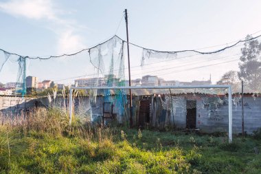 Ağı kırılmış ve terk edilmiş ahşap soyunma odaları terk edilmiş futbol sahasında uzun çimenler.