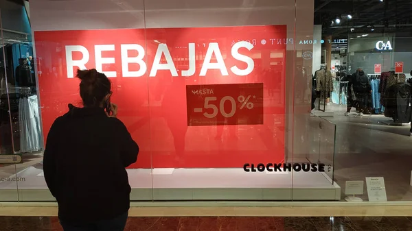 スペイン スペイン 2020年12月23日にファッション店Cyaの大売り上げというお店の窓を見て背を向けて電話で話す若い女性 — ストック写真