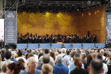 Coruna, İspanya. Seyirciler, 17 Ağustos 2019 'da Plaza de Maria Pita' da düzenlenen Galiçya Senfoni Orkestrası 'nın konserini izliyor, oturuyordu ve ayakta duruyordu.