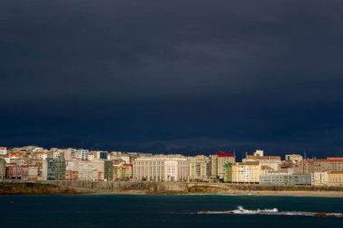 Coruna-İspanya. Akşam ışığında binalar, 7 Şubat 2021 'in üzerinde kara fırtına bulutları var.