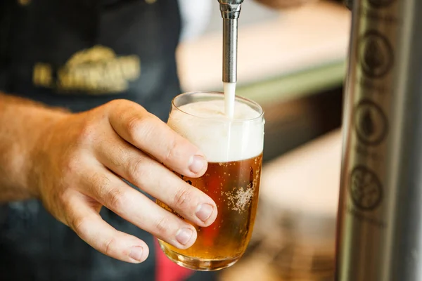 waiter serving a beer with foam