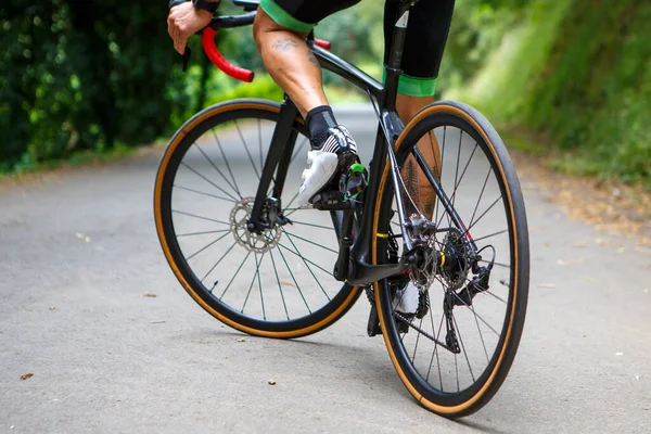 Bisikletli bisikletçi bir yol bisikletçisi, sabahları bisiklet bisikletçisi, bisikletçilerin ayakkabılarının ayrıntıları.