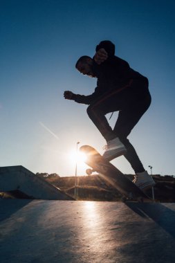 Kaykaycı gün batımına karşı atlama numarası yapıyor.