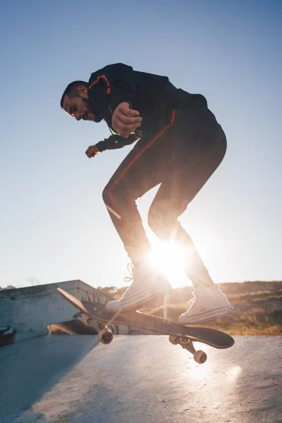 スケートボーダー 夕日とボード上のトリックをジャンプ — ストック写真