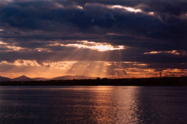 Fırtına bulutlarının içinden geçen güneş ışınlarının resmi