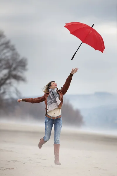 Girl jumping with umbrella — Stock Photo, Image