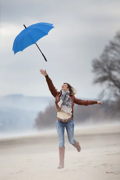 Girl jumping with umbrella — Stock Photo, Image