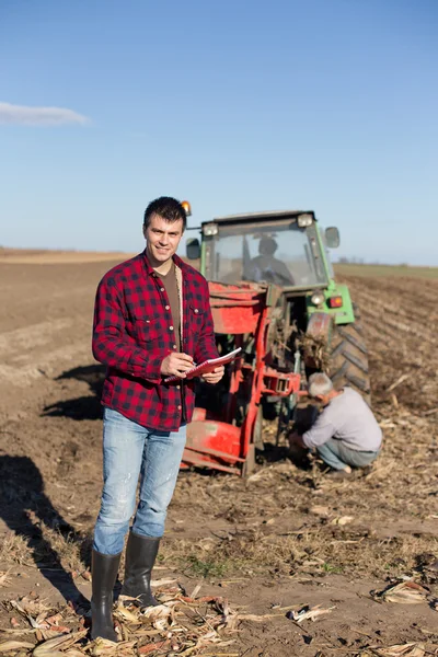 Agricultor com trator no campo — Fotografia de Stock