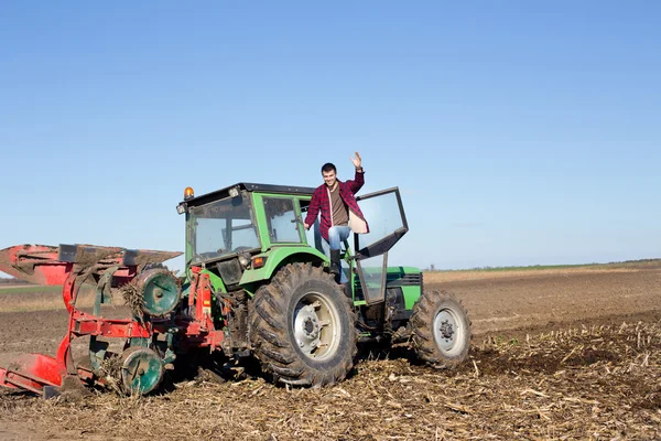 Landwirt steht auf dem Traktor — Stockfoto