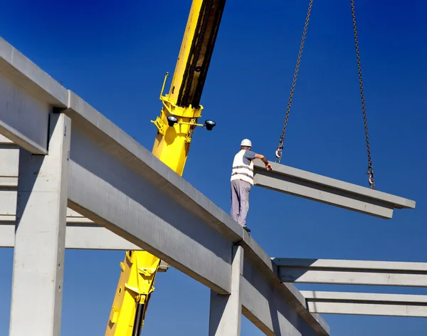 Height worker placing truss on building skeleton — Stock Photo, Image