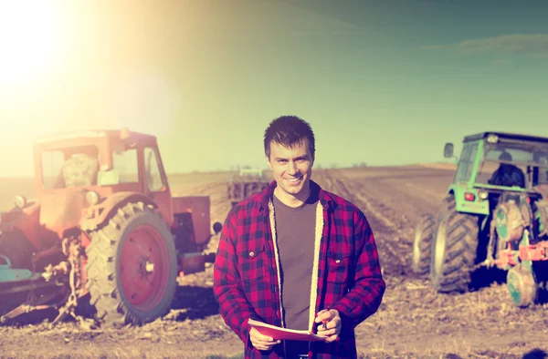 Landwirt mit Traktoren auf dem Feld — Stockfoto