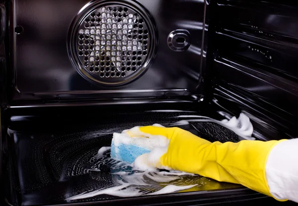 Woman cleaning oven — Stock Photo, Image