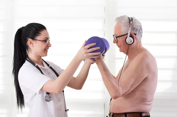 Nurse helping old man with dumbbells — Stock Photo, Image