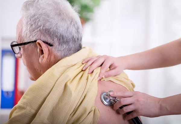 Krankenschwester hört Herzschlag eines alten Mannes — Stockfoto