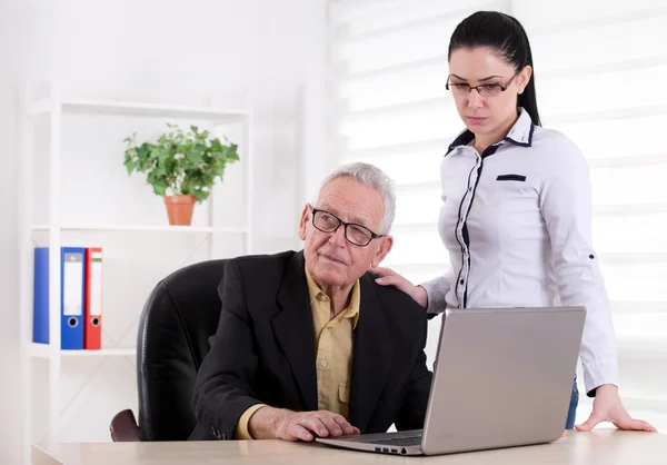 Senior man and girl in the office — Stock Photo, Image