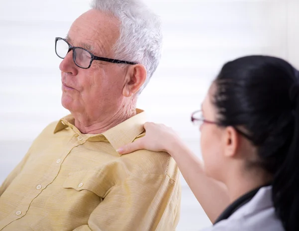 Verpleegkundige geruststellend senior man — Stockfoto