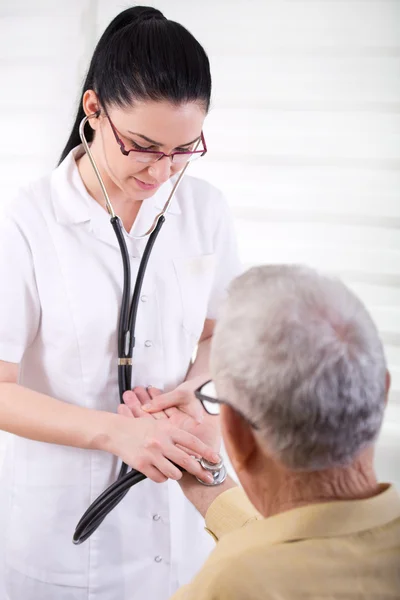 Krankenschwester hört Herzschlag eines alten Mannes — Stockfoto