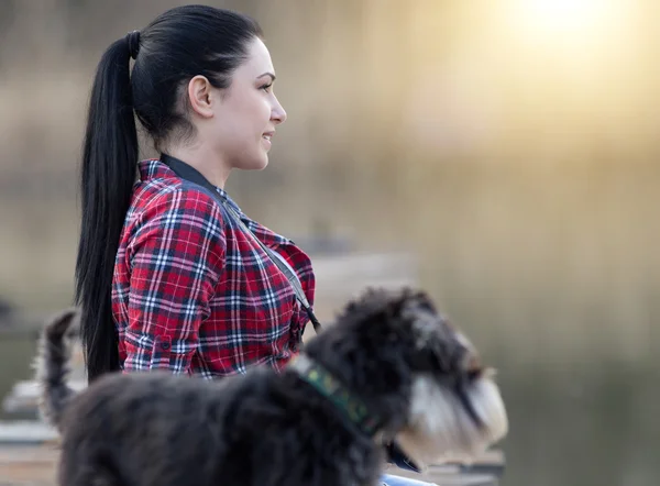 Menina com cão na doca de madeira — Fotografia de Stock